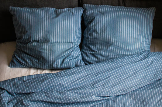 a bed with two pillows and a blanket on top of it